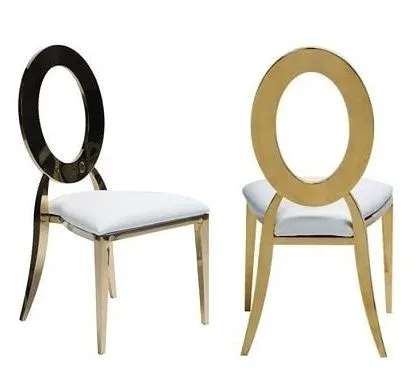 Two chairs with white seats and gold frames, one with a dark oval back, the other with a gold oval back.