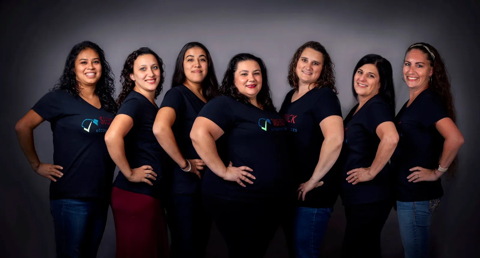 Seven women in black shirts with a logo and text that reads "SIDERICK ACCOUNTING SERVICES.