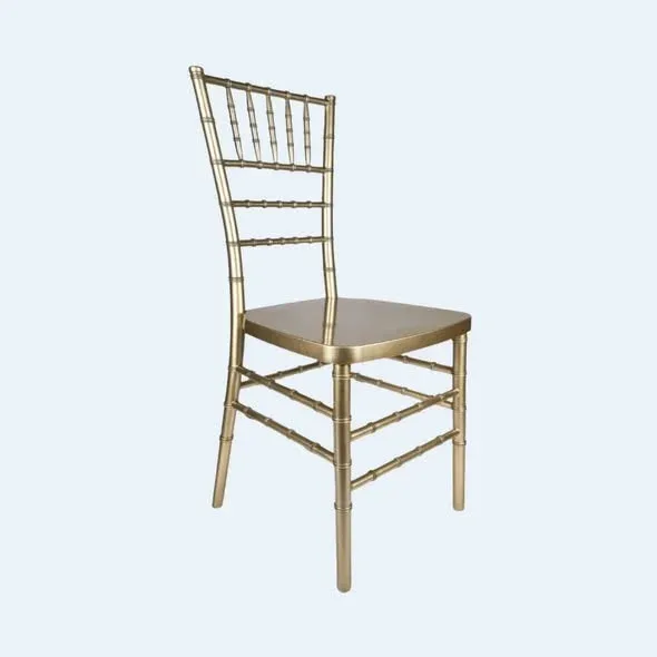 A gold chair with a bamboo-style frame and a square seat, angled against a light blue background.